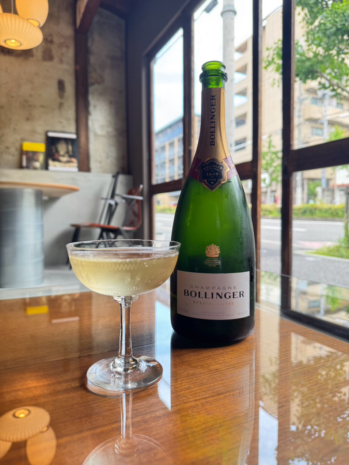 Bello Vero のグラスシャンパーニュ、クープ型のグラスに注がれた Bollinger Special Cuvée とボトル