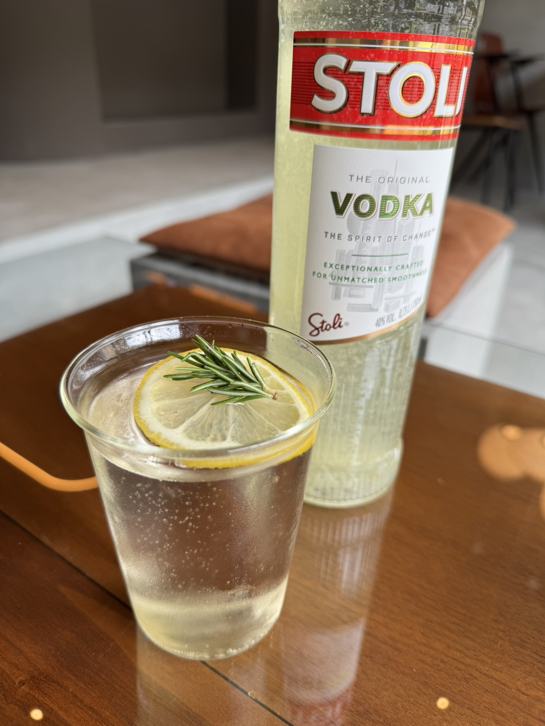 Bello Vero のリモーネ、自家製レモンサワー。グラスにレモンとローズマリーを浮かべ、奥にウォッカ Stoli のボトル